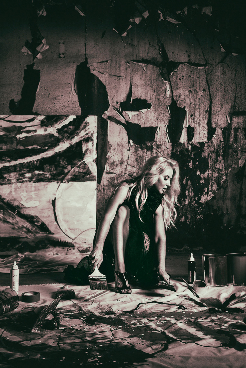 Niki Woehler in a black dress black and  white photo surrounded by paintings